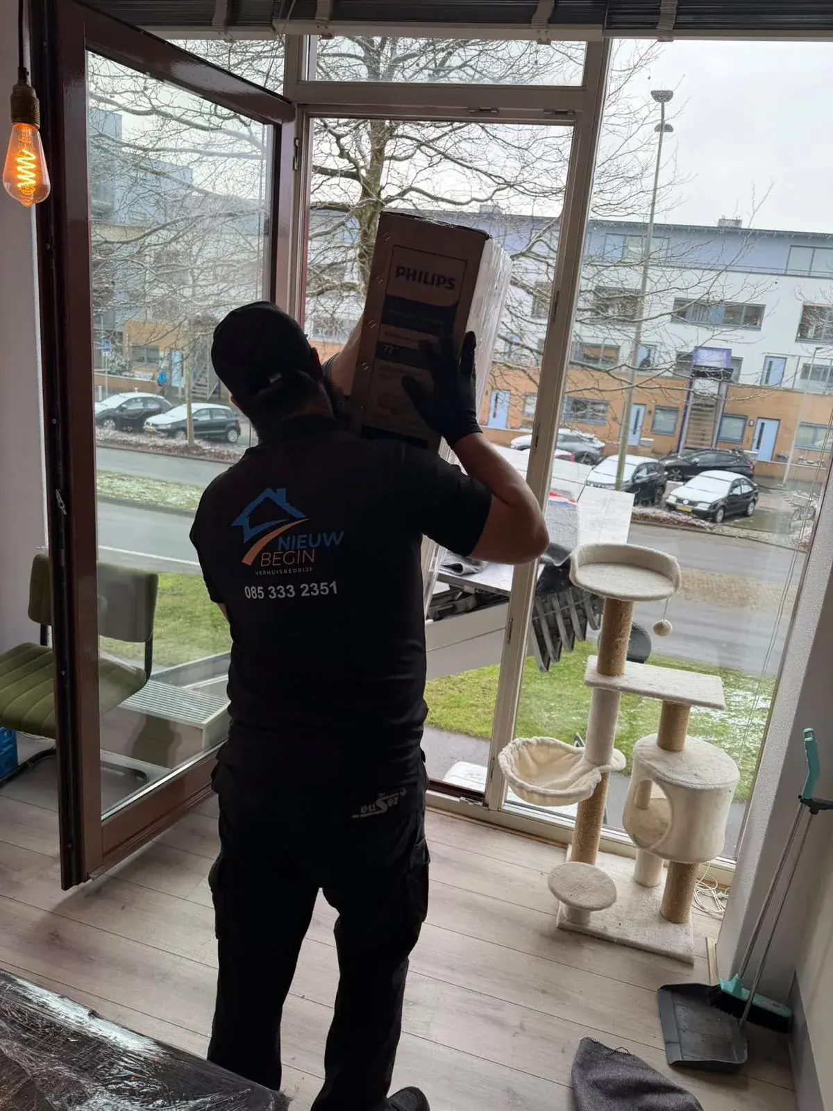 Verhuizer tilt een doos in een appartement
