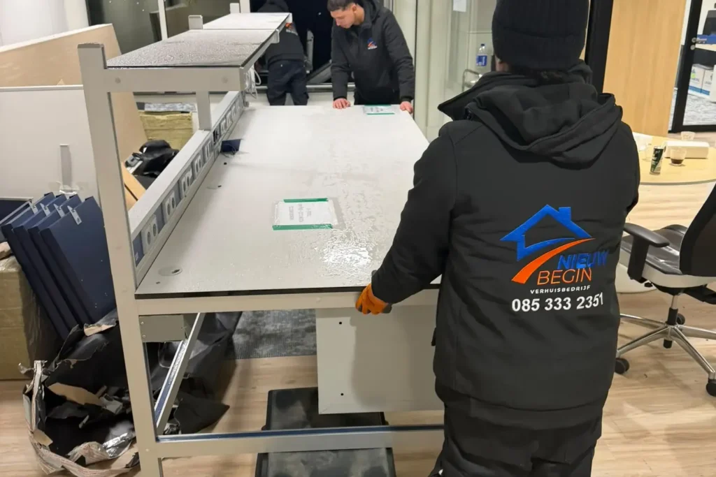 Verhuizer demonteert een bureau op kantoor