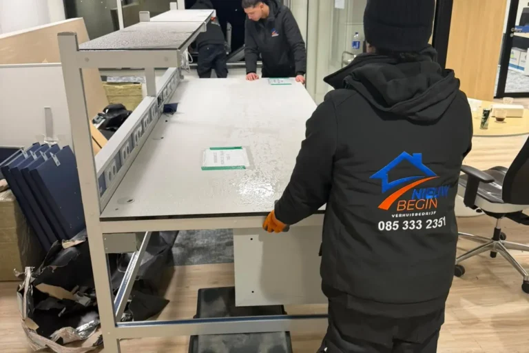 Verhuizer demonteert een bureau op kantoor