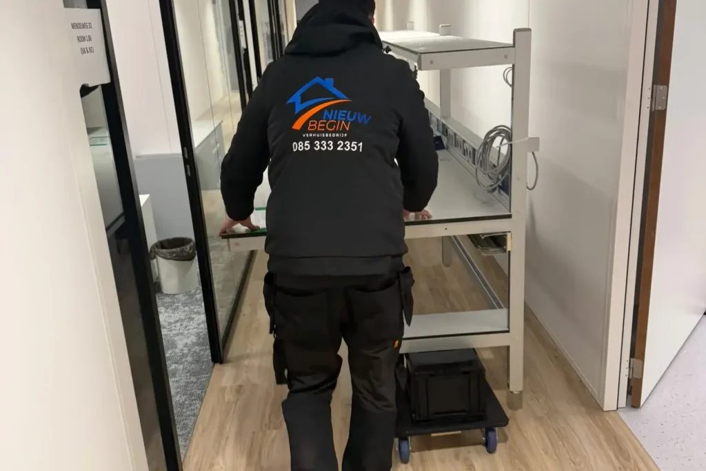 Verhuizer rijdt een kar door een kantoorgang