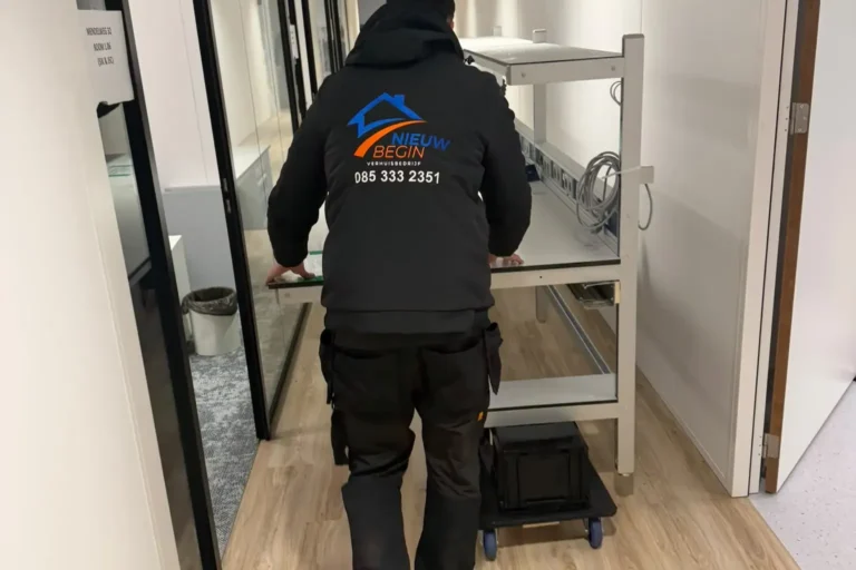 Verhuizer rijdt een kar door een kantoorgang