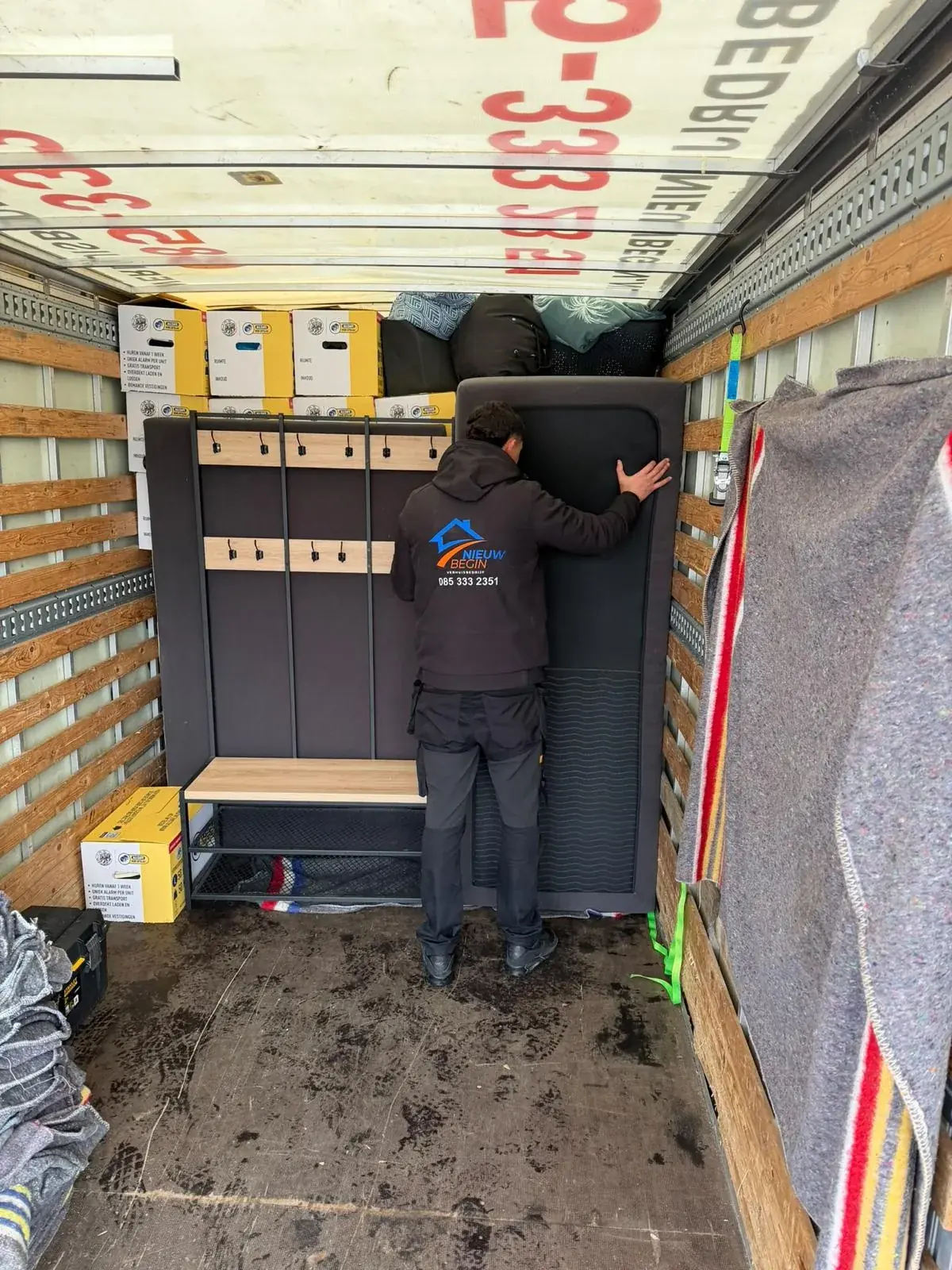 Verhuizer zet een kast vast in de wagen