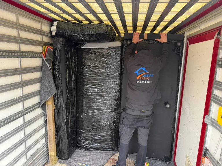 Verhuizer zet meubels in folie vast in de wagen