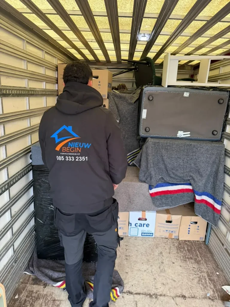 Verhuizer stapelt dozen en meubels in de wagen
