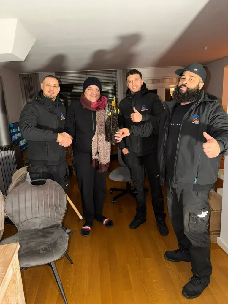 Tevreden klanten met de ploeg van Nieuw Begin na de verhuizing