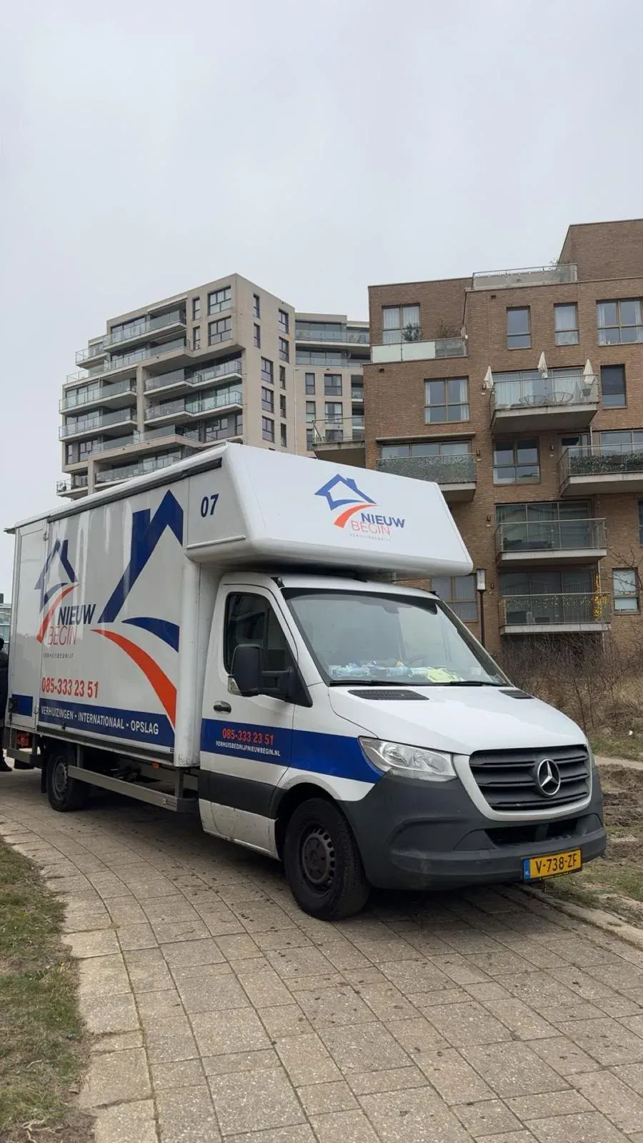 Wagen van Nieuw Begin voor een flatgebouw